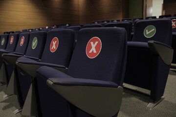 Asientos marcados en sala de cine, marca de no sentarse para distanciamiento social. concepto de...