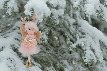 Winter angel on a snowy tree.Christmas and New Years . Christmas symbol. Snowfall. Snow fairy. Christmas tree toy. 