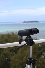 Pair of telescopes mounted on a tripod overlook the beach