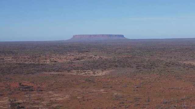 a morning aerial shot, flying backwards, of mt conner in the northern territory of australia
