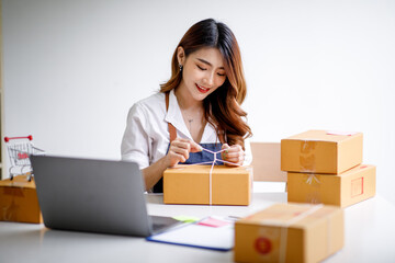 Portrait of Starting small businesses SME owners female entrepreneurs working on receipt box and check online orders to prepare to pack the boxes, sell to customers, sme business ideas online.