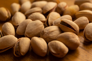 close up of many pistachios on a wooden background