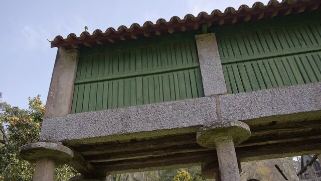 Traveling of stone granary with parts of green wood and trees in the background (side view)