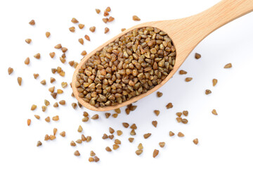 uncooked buckwheat in the wooden spoon, isolated on the white background, top view