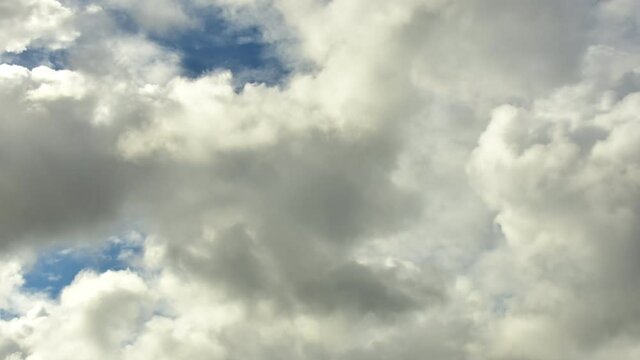 4K Time lapse, Gray and white rolling puffy clouds floating in the sky.