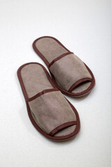 Gray one-off slippers for hotel on a gray background