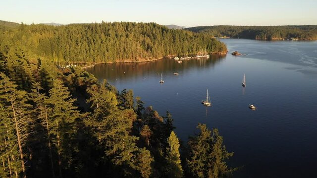 Cinematic 4K aerial drone trucking footage of Bay Head Marina, sailboats and yachts anchored near Orcas Village by the Harney Channel in the San Juan Islands in Washington