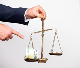 Money weighing on justice scale in business man hand. Payment balance and tax