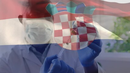 Animation of flag of croatia waving over doctor wearing face mask and holding vaccine - Powered by Adobe