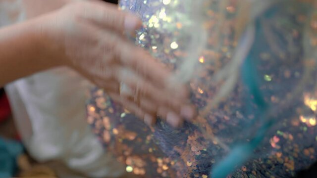 Hand touching sparkling paillette dress