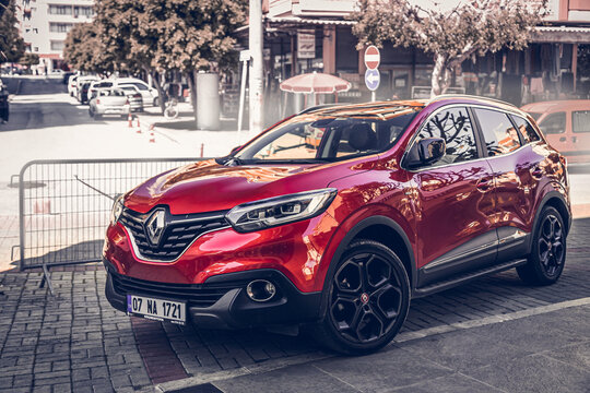Alanya, Turkey &ndash; April 12 2021:     red  Renault Captur   parked  on the street in city against the backdrop of a   buildung,  shops, trees