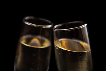 Two glasses of champagne on black background.