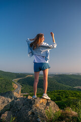 Fototapeta premium Girl in shorts on the top of the mountain