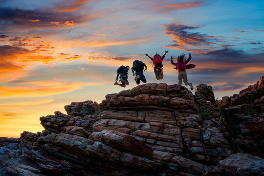 Hikers walking with backpack on a mountain at sunset. traveler going camping. travel concept.