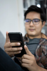 Young man using smart phone in the living room.