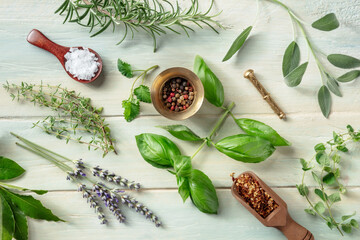Fototapeta na wymiar Fresh herbs, shot from above on a wooden background with salt and pepper. Rosemary, lavender, bay leaf, thyme, basil, sage and other aromatic plants