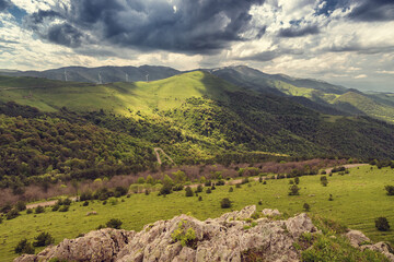Panorama of a dirt village road leading to the Pushkin pass in the mountains of Armenia. Wind farm...