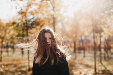 young teenage girl walking in autumn park