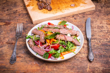 Healthy vegetable salad with beef steak on a plate, rustic style