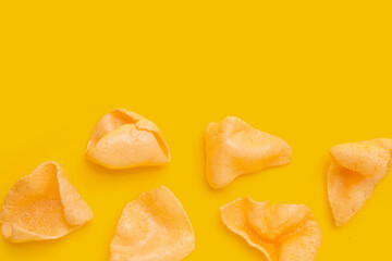 Prawn crackers on yellow background. Shrimp crispy rice snack