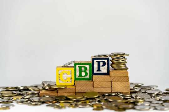 Forex GBP concept with wooden blocks and coins. Forx GBP letters on wooden blocks sorrounded with money