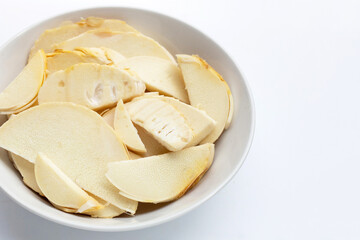Bamboo shoots in white bowl on white background.