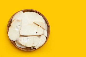 Bamboo shoots in bamboo basket on yellow background.