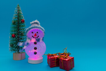 Glowing snowman, presents and Christmas tree with copy space.new year celebration.