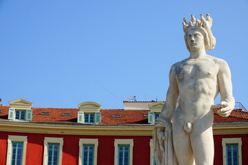 Détails de la statue d'Apollon, dans la Place Masséna de Nice, avec les bâtiments rouge typique de son architecture néoclassique