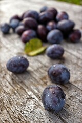 Plums, autumn fruits on rustic wooden table