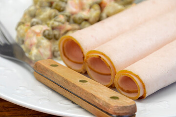 tranches de blancs de poulet cuit et macédoine de légumes dans une assiette