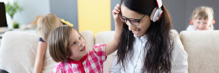 Small children prevent their mother from doing laptop work at home