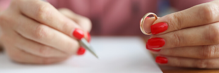 Woman is applying for divorce and is holding wedding ring