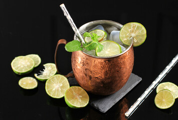 Cold Moscow Mule Coctail on Copper Mug  with Ginger Beer, Lime,  and Vodka, Garnish with Mint Leaf....