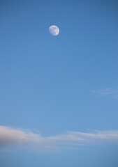 moon and clouds against blue sky