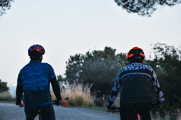 Amateur cyclists riding their bikes in the mountains while talking to each other