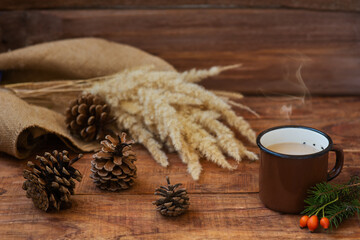 Winter, Christmas background in rustic style. A metal vintage mug with hot milk tea stands on a tablecloth
