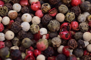  Colored peppercorns on a wooden bowl on a white background. Food. Spices.