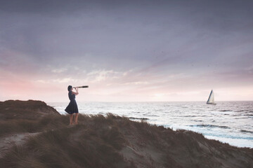 woman with binoculars observes the infinite ocean , concept of freedom and travel