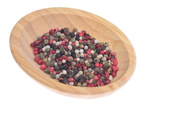  Colored peppercorns on a wooden bowl on a white background. Food. Spices.