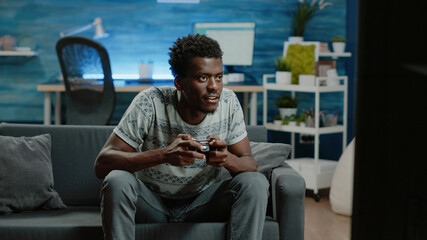 Young adult losing at video games on TV console with joystick. Frustrated person playing online game with controller on television for entertainment and free time activity. Man gaming © DC Studio