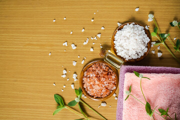 Fototapeta na wymiar Sea salt and Himalayan Salt with massage oil and towel on wooden background. top view with free space. aroma therapy spa set organic herbal for vacation in holidays. for luxury bathroom hotel concep.