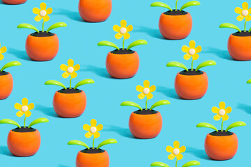 Environmental issues inspired pattern concept. Artificial yellow flowers with small solar cell within against blue background