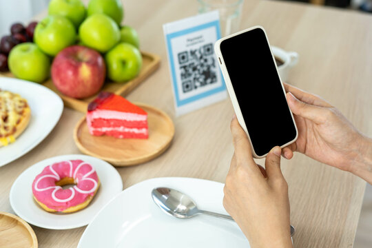 Women use phone to scan qr code to select food menu and collect points. Scan to get discounts or pay for food. The concept of using a phone to transfer money or paying money online without cash.