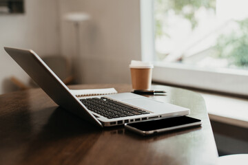 Workplace with notebook laptop and coffee cup Comfortable work table in cafe.