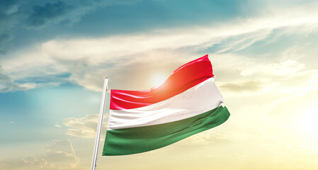 Hungary national flag cloth fabric waving on beautiful sky - Image