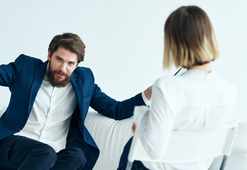 A man sits on a sofa next to a patient visiting a psychologist problems therapy