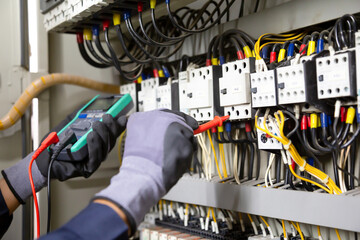Electrician engineer tests electrical installations and wires on relay protection system....