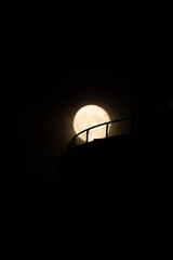 rooftop balcony railing with yellow full moon background Silhouettes
