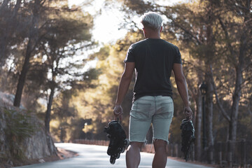 a gay boy riding on in-line skates skating on a road.